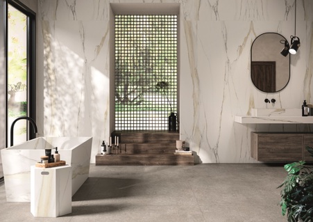 Arredo bagno in gres porcellanato Florim stone. Il pavimento in ceramica Fossil Gray è stato abbinato a un rivestimento realizzato con lastre di grande formato in ceramica Calacatta Gold glossy, insieme creano un ambiente luminoso ed elegante. A completamento dell'arredamento, sempre in ceramica Calacatta Gold glossy, sono stati realizzati una vasca da bagno e un tavolino su misura.