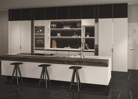 Gritty kitchen where the island kichen countertop is made of glossy Marble Breccia Capraia porcelain stoneware. The front of the kitchen island is covered in Color White matte. The same material was used to make the full-height cabinet doors and the shelves. In contrast, the flooring and the shelf backing have been made of Marble Marquinia ceramic in glossy and matte finishes, respectively.