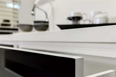 Particolare di cucina realizzata con piano in Color White e cassetti rivestiti in Color Black entrambe ceramiche della linea Florim Stone