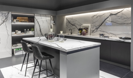 Cucina moderna composta da dispensa con scorrevoli ante a tutta altezza, top isola, top e schienale cucina in gres porcellanato Marble Breach matte.