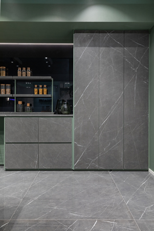 Cucina industriale con mensole, cassettoni e ante a tutta altezza realizzate in gres Marble Gray matte