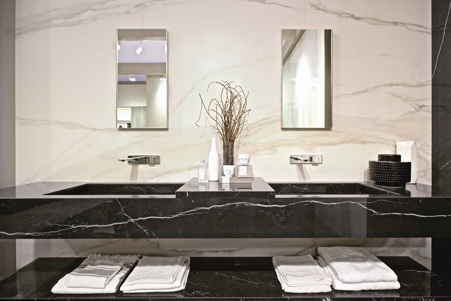 In contrast to the book match Marble Calacatta Gold stoneware wall tiles, in this minimal style bathroom, a suspended sink in glossy Marble Marquinia has been created, combined with a suspended shelf in the same material.