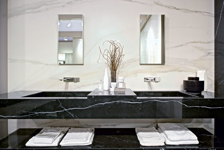 Modern bathroom with glossy Calacatta Gold cladding and bathroom top with integrated sink and glossy Marble Marquinia stoneware shelf