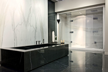 Bagno minimal dai forti contrasti con pavimentazione e vasca in Marble Marquinia glossy e rivestimento bagno e doccia in Marble Calacatta Glod glossy a macchia aperta