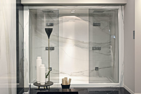 Shower cladding with rectangular drain covered with glossy Calacatta Gold stoneware slabs