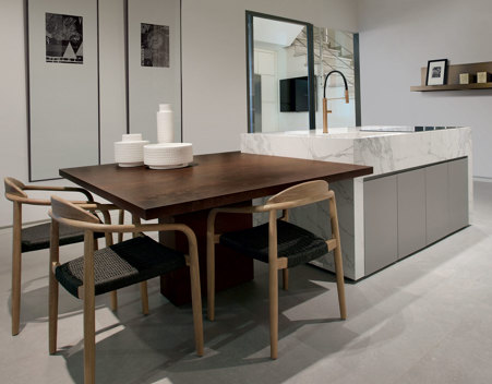 Modern kitchen island characterized by the contrast between the snack top made of matte Metal Russet and the part of the containment worktop covered in glossy Marble Statuario